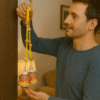 Man Hanging a Handcrafted Yellow Macrame Bell