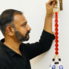 Man Hanging a Handcrafted Macrame Bell